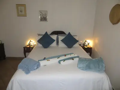 a bedroom with a white bed with blue pillows at At Rest Bushstay in Hoedspruit