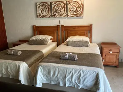 two beds sitting next to each other in a room at Acasia Guest Lodge in Komatipoort