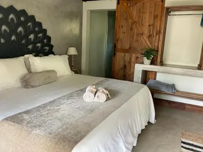 a bedroom with a bed with two slippers on it at Acasia Guest Lodge in Komatipoort