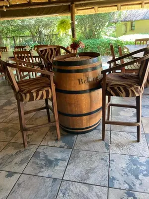 a table and chairs and a barrel with a plant in it at Acasia Guest Lodge in Komatipoort