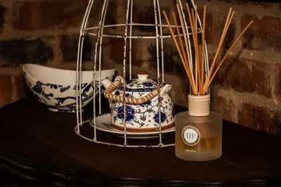 a table with a vase and a container with sticks at Maryah House in Pretoria