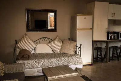 a living room with a couch and a refrigerator at Maryah House in Pretoria