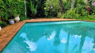 a swimming pool with blue water in a yard at Maryah House in Pretoria