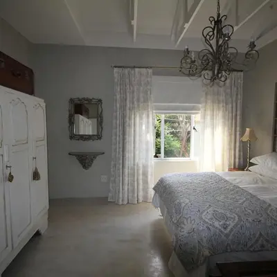 a bedroom with a bed and a window and a chandelier at Maryah House in Pretoria
