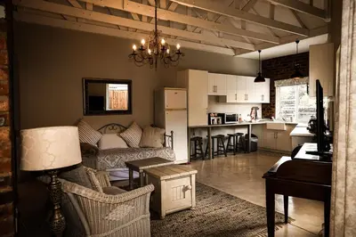 a living room and kitchen with a couch and a table at Maryah House in Pretoria