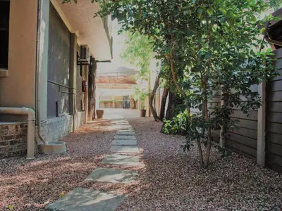 an empty alley with a tree and a building at Palm Inn Guesthouse in Onverwacht