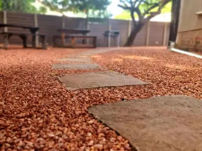 a patio with a bunch of leaves on the ground at Palm Inn Guesthouse in Onverwacht