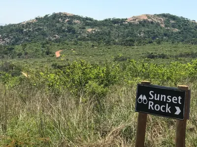 a sign that says sunset rock in front of a hill at Ndhula Luxury Tented Lodge in White River