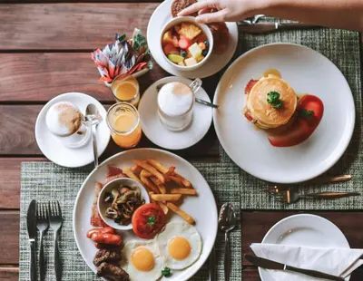 a table with plates of breakfast food on it at Ndhula Luxury Tented Lodge in White River