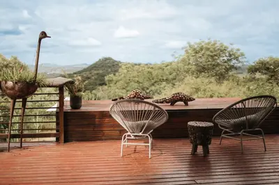 two chairs and a table on a wooden deck at Ndhula Luxury Tented Lodge in White River