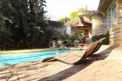 a lounge chair sitting next to a swimming pool at Camellia Haven in Pretoria