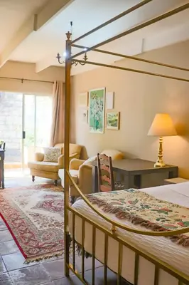 a bedroom with a bed and a living room at Camellia Haven in Pretoria