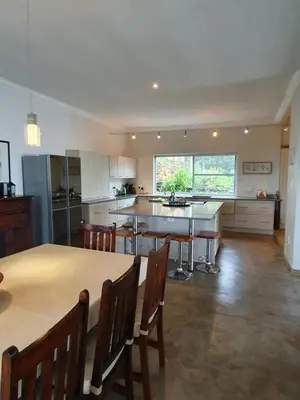 a large kitchen with a table and chairs in it at Lind End Guest Farm in Haenertsburg