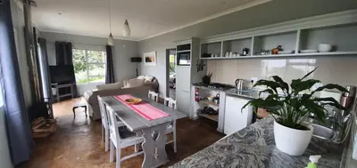 a kitchen and living room with a table and a couch at Lind End Guest Farm in Haenertsburg