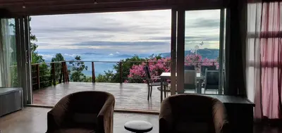 a balcony with two chairs and a view of a deck at Lind End Guest Farm in Haenertsburg