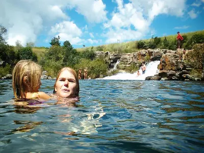 two women swimming in the water in a river at Thaba Tsweni Lodge & Safaris in Graskop