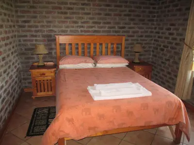 a bedroom with a bed with two night stands and two lamps at Thaba Tsweni Lodge & Safaris in Graskop