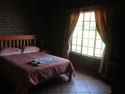 a bedroom with a bed and a large window at Thaba Tsweni Lodge & Safaris in Graskop