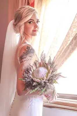 a woman in a wedding dress holding a flower bouquet at Casa Toscana Lodge in Pretoria