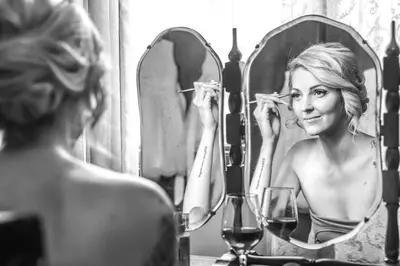 a woman brushing her teeth in front of a mirror at Casa Toscana Lodge in Pretoria