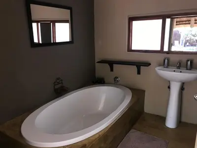 a bathroom with a large tub and a sink at NIANI tented Chalet in Hoedspruit
