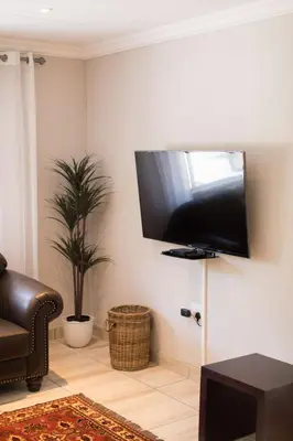 a living room with a flat screen tv on the wall at Klippan River Lodge in Groblersbrug