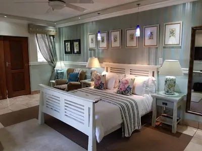 a bedroom with a large white bed and a chair at Pheasant Hill Bed and Breakfast in Rietvalleirand