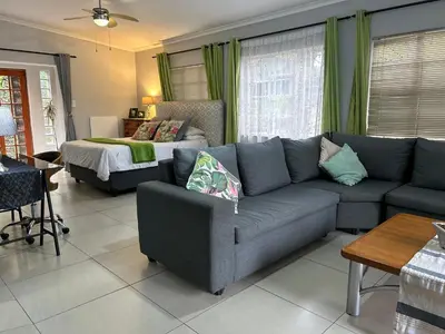 a living room with a couch and a bed at Sabie Self Catering Apartments in Sabie