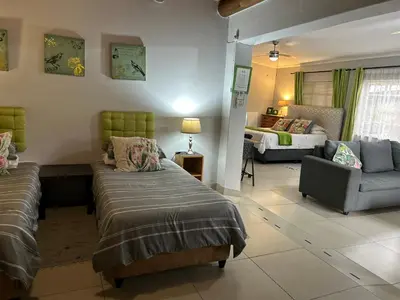 a living room with two beds and a couch at Sabie Self Catering Apartments in Sabie