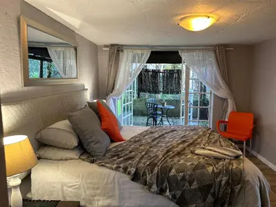a bedroom with a bed and a view of a patio at Sabie Self Catering Apartments in Sabie