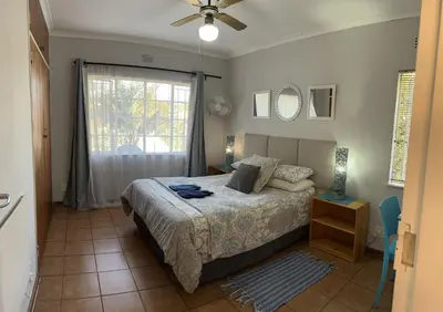 a bedroom with a bed and a window at Sabie Self Catering Apartments in Sabie