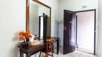 a bathroom with a wooden table and a mirror at Gaza Homes Self Catering Apartments in Nelspruit