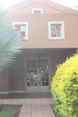 a front door of a house with windows at Batter Boys Guest House in Pretoria