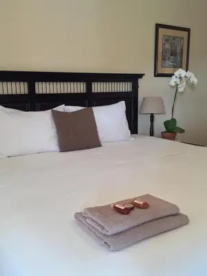 a towel on a bed with a robe on it at Batter Boys Guest House in Pretoria