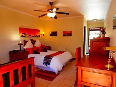 a bedroom with a bed and a ceiling fan at African Footprints Lodge in Midrand