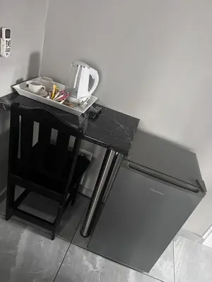 a black table with a chair next to a refrigerator at KwaSiya Guest House in Nelspruit