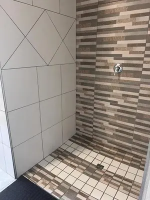 a bathroom with a shower with a tiled shower at KwaSiya Guest House in Nelspruit