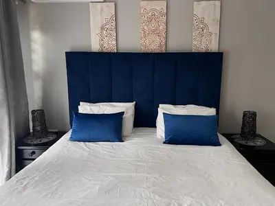 a large bed with two blue pillows on it at KwaSiya Guest House in Nelspruit