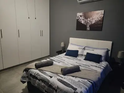 a bedroom with a bed with blue pillows on it at Le Grix Guesthouse in Nelspruit