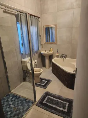 a bathroom with a tub and a toilet and a sink at Le Grix Guesthouse in Nelspruit