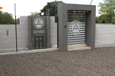 a building with a door with a sign on it at Millennium Body Guards Guesthouse in Hartbeespoort