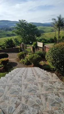 a stone walkway with a view of the hills at Hamba Kancane Ma-Africa Guest House in Graskop