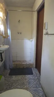 a bathroom with a shower and a toilet and a sink at Hamba Kancane Ma-Africa Guest House in Graskop