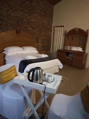 a hotel room with two beds and a tea kettle on a table at Hamba Kancane Ma-Africa Guest House in Graskop