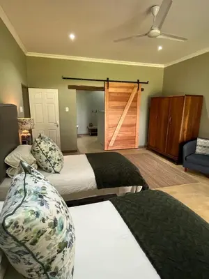 a bedroom with two beds and a sliding door at Ploughman’s Rest in Ohrigstad
