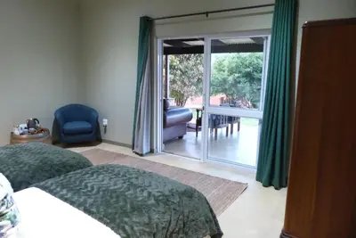a bedroom with a bed and a sliding glass door at Ploughman’s Rest in Ohrigstad