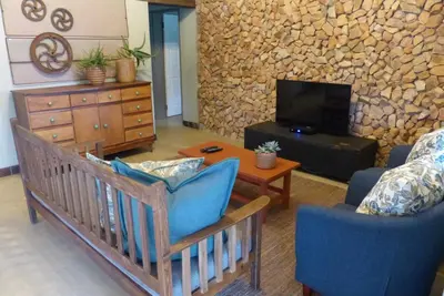 a living room with a couch and a table and a tv at Ploughman’s Rest in Ohrigstad