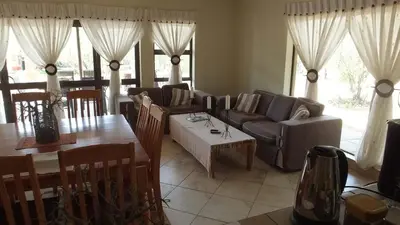 a living room with a couch and a table at Baobab - NUDE - SunEden Family Naturist Resort in Pretoria