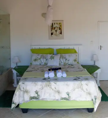 a bedroom with a green bed with two stuffed animals on it at Baobab - NUDE - SunEden Family Naturist Resort in Pretoria