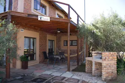 a patio of a house with a table and chairs at Baobab - NUDE - SunEden Family Naturist Resort in Pretoria